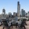a group of chairs around a fire pit with a city skyline behind